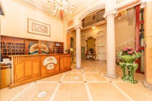 une grande chambre avec colonnes et vase au sol dans l'établissement Hotel Pallanza, à Verbania
