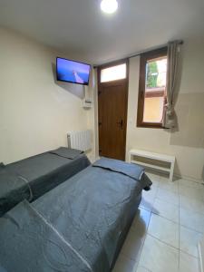a bedroom with a bed and a flat screen tv at RENT APPART - La Garenne Colombes in La Garenne-Colombes