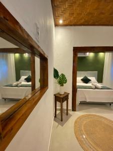 a room with two beds and a mirror at Alebahli Hospedagem Ilhabela in Ilhabela