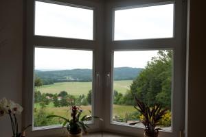 two windows in a room with a view of a field at Bergrestaurant Schwedenstein in Steina