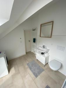 ein weißes Bad mit einem Waschbecken und einem WC in der Unterkunft Helle 2 Zi. Wohnung nähe Flughafen München in Haimhausen