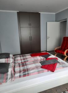 エゲルにあるKodály Apartmanのベッドルーム1室(ベッド1台、赤い椅子付)