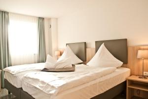 a bedroom with a large bed with white pillows at Ostsee Ferienhäuser in Waabs