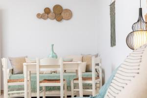 a dining room with white chairs and a table at GOLDEN COAST NAXOS in Agios Prokopios