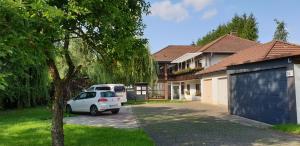 een witte auto geparkeerd voor een huis bij Froschkönig mit Teichblick in Trendelburg