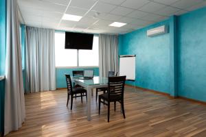 a conference room with a table and chairs and a whiteboard at Hotel Belvedere in Porto SantʼElpidio