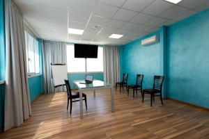 una sala conferenze con tavolo, sedie e schermo di Hotel Belvedere a Porto SantʼElpidio