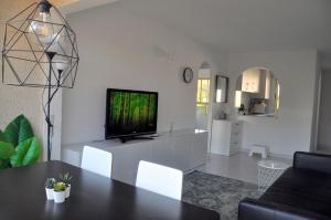 una sala de estar con TV en un armario blanco en Apartamento con piscina y parking, en El Campello