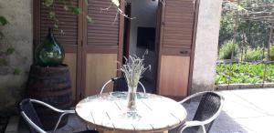 a table with chairs and a vase on a patio at Depandance Schito in Celso