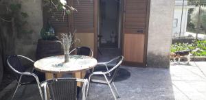 a table and chairs in front of a door with a dog at Depandance Schito in Celso