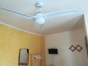 Habitación con ventilador de techo blanco y espejo. en B & B Color Rovereto, en Rovereto