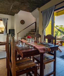 uma sala de jantar com uma mesa de madeira e cadeiras em Areia Branca Apart Hotel em Morro de São Paulo