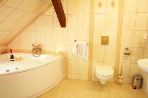 ein Badezimmer mit einer Badewanne, einem WC und einem Waschbecken in der Unterkunft Willa Kraj in Ustroń