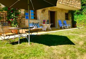 un patio con mesa, sillas y sombrilla en Loft 80 mts en un entorno natural., en Mieres