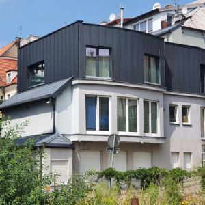 a house with a black roof at Apartamenty Kąpielowa Biały in Ełk