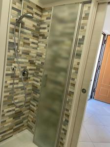 a shower with a glass door in a bathroom at Blu Mare House in Cecina +4 photos