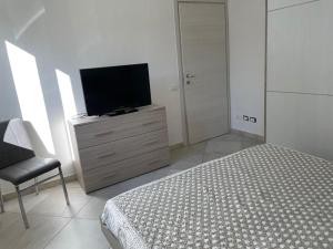 a bedroom with a bed and a television on a dresser at Blu Mare House in Cecina