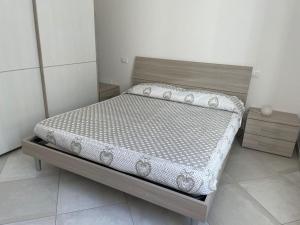 a bed in a small room with a white wall at Blu Mare House in Cecina