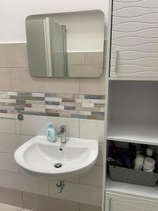 a bathroom with a sink and a mirror at Appartamento a 400mt dal mare in Cecina