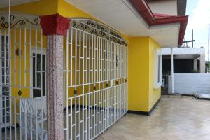 una puerta amarilla y blanca en una casa en Compleet vrijstaand woonhuis Paramaribo, en Paramaribo