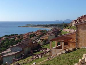 un pueblo en una colina con el océano en el fondo en Corallo Vacanze, en Villaputzu