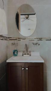 une salle de bain avec un lavabo et un miroir dans l'établissement Villa Bonita, à Isla Mujeres