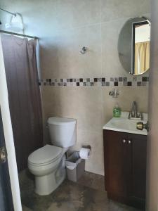 une salle de bain avec toilettes, lavabo et miroir dans l'établissement Villa Bonita, à Isla Mujeres 18 autres photos