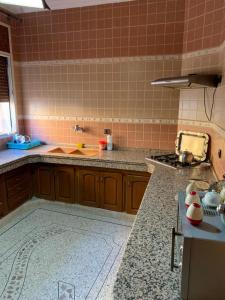 a kitchen with brown cabinets and a counter top at Cozy Home in Azrou in Azrou