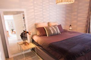 a bedroom with a bed and a mirror at Spacious and light Kalk Bay Garden Apartment in Kalk Bay