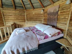 a bed sitting inside of a wooden cabin at Lapuanjoen Rantakeidas in Voltti