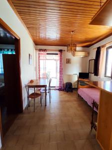 um quarto com uma mesa e uma cama e uma sala de jantar em Limanaki em Kími