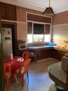La cuisine est équipée d'une table, de chaises et d'un réfrigérateur. dans l'établissement Cozy Home in Azrou, à Azrou
