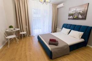 een slaapkamer met een groot bed en een tafel bij Studio near metro Pushkinska, Universytet - Mayakovskogo str. 5-3 in Charkov