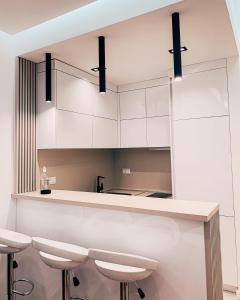 a kitchen with white cabinets and bar stools at Rent apartment lux soho city Bar in Bar