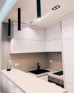 a kitchen with white cabinets and a white counter top at Rent apartment lux soho city Bar in Bar
