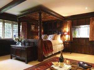 
a bedroom with a large bed and a large window at Abbots Grange Manor House Hotel in Broadway
