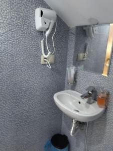 a bathroom with a sink and a hair dryer on the wall at hotel alismereti in Zekari +44 photos