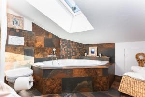 een grote badkamer met een bad en een toilet bij Ferienwohnung Maisonette Höttl in Saalfelden am Steinernen Meer