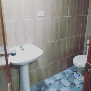 La salle de bains est pourvue d'un lavabo et de toilettes. dans l'établissement Habitaciones El Trébol, à Playas