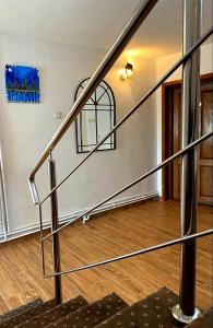 a metal staircase in a room with a wooden floor at Casa Topazz in Târgu Jiu
