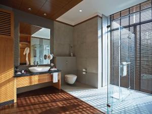 un bagno con lavandino, water e specchio di Taj Damdama Lake Resort & Spa, Gurugram a Gurgaon