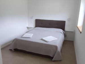 a bedroom with a bed with two towels on it at Casa GABRI in Ledro