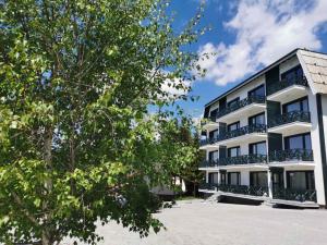 a large white building with trees in front of it at Apartman Srebrna pahulja in Kopaonik