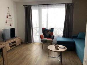 ein Wohnzimmer mit einem blauen Sofa und einem Tisch in der Unterkunft Apartman Srebrna pahulja in Kopaonik