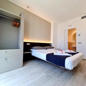 a bedroom with two beds and a flat screen tv at Brezza Marina in Porto Recanati