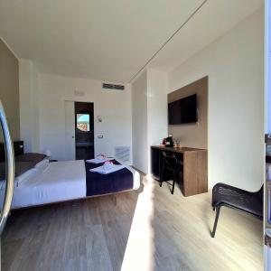 een slaapkamer met een bed, een bureau en een televisie bij Brezza Marina in Porto Recanati