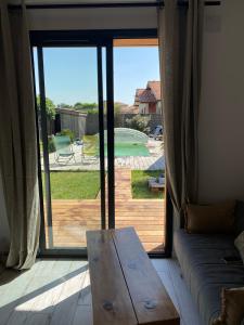 - un salon avec un canapé et une grande porte coulissante en verre dans l'établissement L'annexe, au Teich