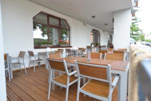 un restaurante con mesas de madera y sillas en una terraza en Hotel Laguna & restaurant, en České Budějovice