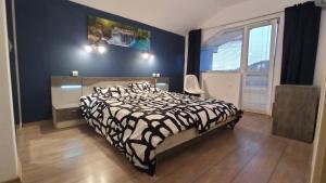 a bedroom with a black and white bed and a window at Arode Villa Ovidius in Balchik