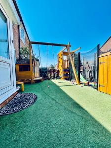 un parque infantil con alfombras verdes y un columpio en Canterbury romantic modern home en Goodnestone